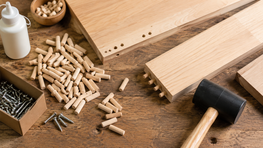 Woodworking workbench with wooden dowel pins, screws, a drilled joint, and wood glue