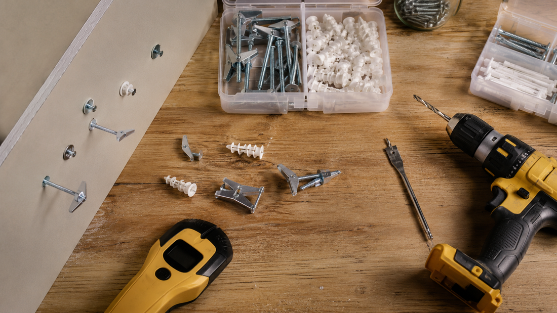 Home improvement workbench with metal and plastic drywall anchors, a drill driver, and a stud finder
