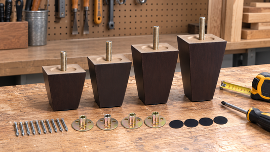 Real wooden furniture legs of varying heights on a workbench with a tape measure and screwdriver