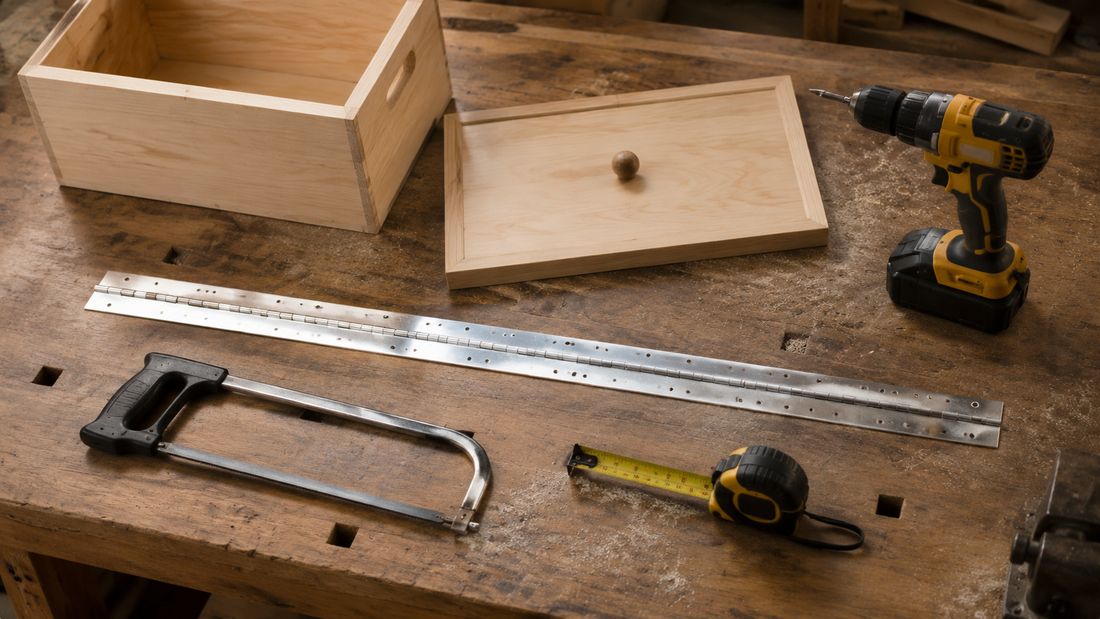 Workbench with a continuous piano hinge, hacksaw, tape measure, and drill driver next to a wooden toy box lid